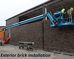 Exterior brick installation using crane.