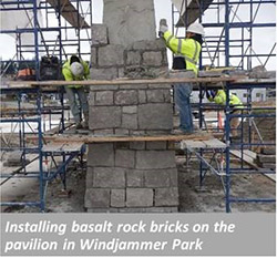 Installing basalt rock bricks on the pavilion in Windjammer park