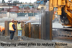 Spraying sheet piles to reduce friction