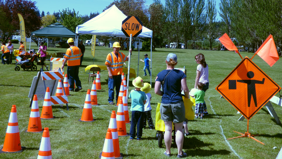 A family speaks with a construction worker among traffic signage and cones